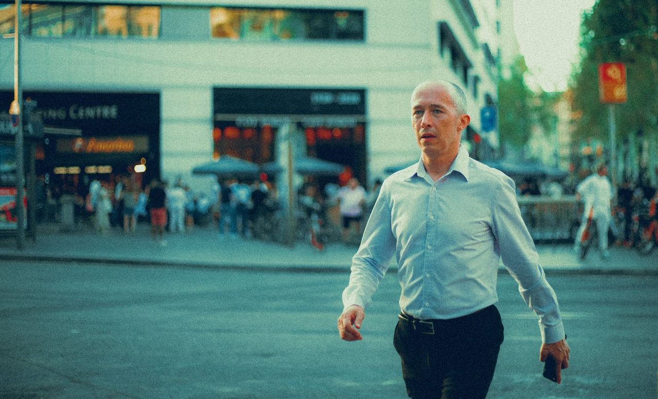 Zelfverzekerde man loopt door een Europese stadsstraat