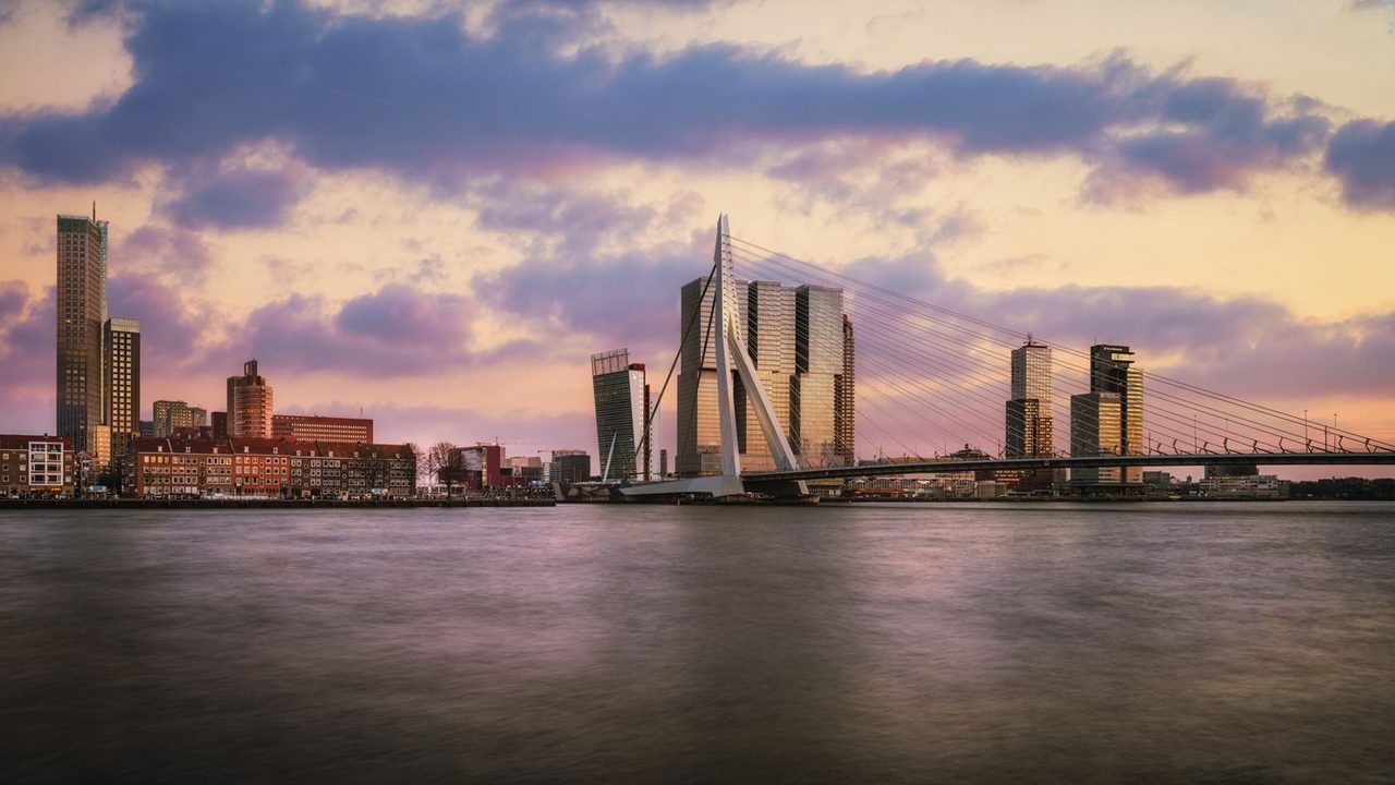 Skyline van Rotterdam met de Erasmusbrug bij zonsondergang